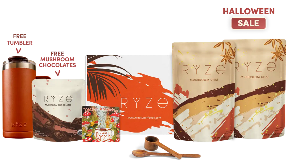 Ryze Halloween sale gift set featuring mushroom chai tea pouches, a chocolate bar, a wooden tumbler, a small wooden spoon, and a branded box, arranged on a white background with promotional text including 'HALLOWEEN SALE' and 'FREE TUMBLER' and 'FREE MUSHROOM CHOCOLATES'.