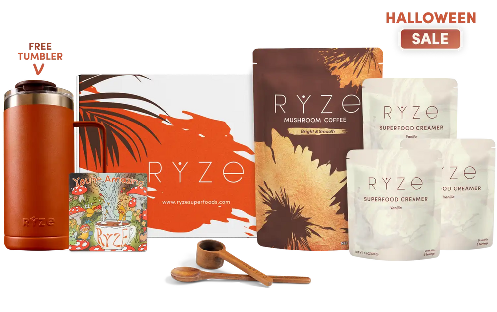 A Halloween-themed RYZE gift set featuring a free tumbler, a large orange and white gift box, a brown mushroom coffee pouch, two white creamer pouches, two wooden measuring spoons, and a small illustrated magnet, arranged on a white background with 'FREE TUMBLER' and 'HALLOWEEN SALE' text overlays.